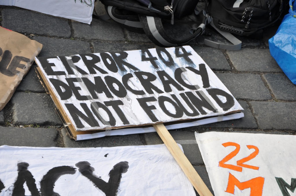 Close-up of a protest sign reading "Error 404: Democracy not found."