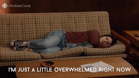 Animated gif: a young woman lies on a couch, saying "I'm just a little overwhelmed right now."