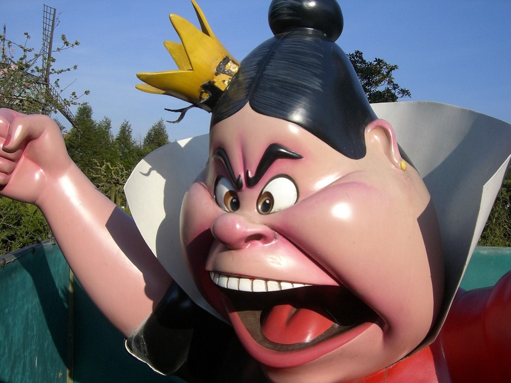 A statue of the Queen of Hearts from Disney's Alice in Wonderland, in closeup showing her clenched fist and screaming, angry face.
