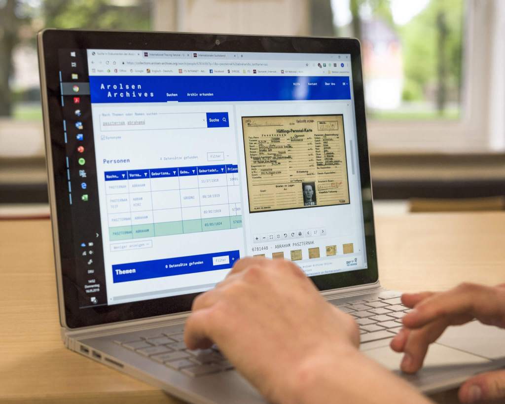 An open laptop, showing the interface for the Arolsen Archives' online archive.